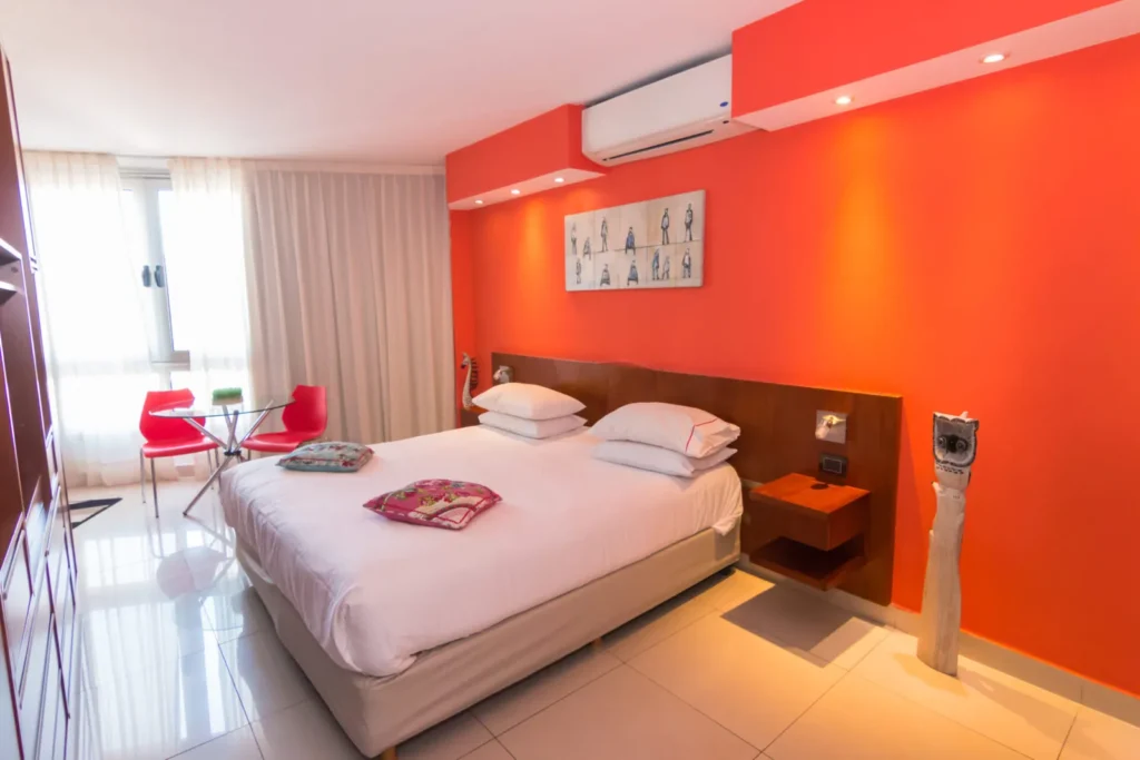 Superior Room with red wall and bed facing the window