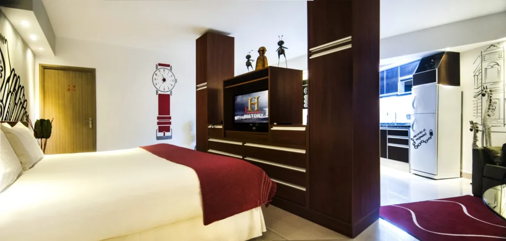Superior Room with bed, burgundy blanket and wooden TV unit