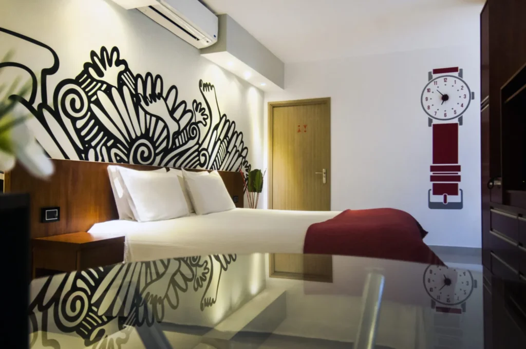 Superior Room with bed, burgundy blanket and black-and-white wall mural