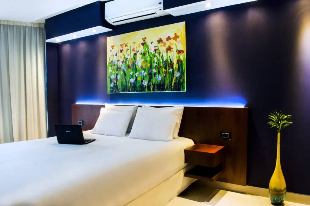 Habitación Superior con cama y cuadro de flores sobre pared azul oscura