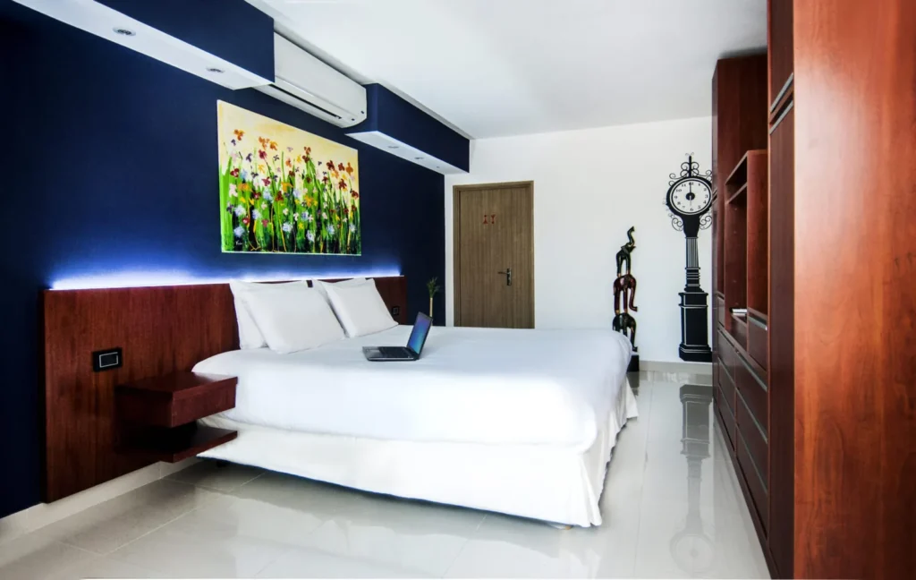 Cama y cuadro de flores sobre pared azul en habitación Superior