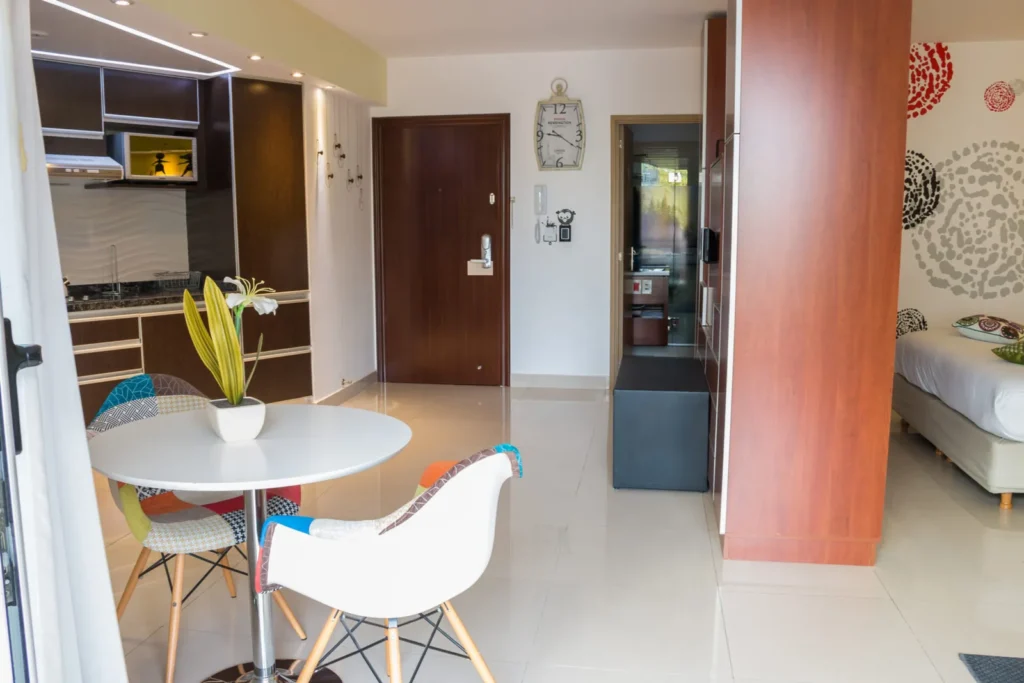 Comedor con mesa blanca y sillas de diseño junto a la cocina integrada