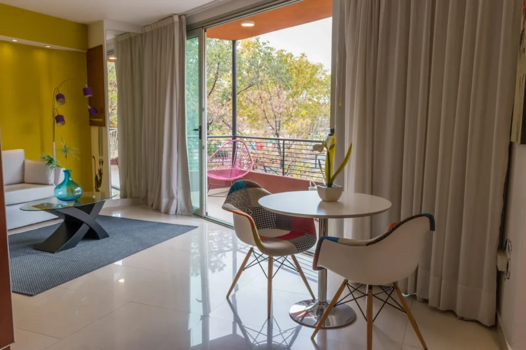 Comedor junto al ventanal con balcón y vista a la ciudad