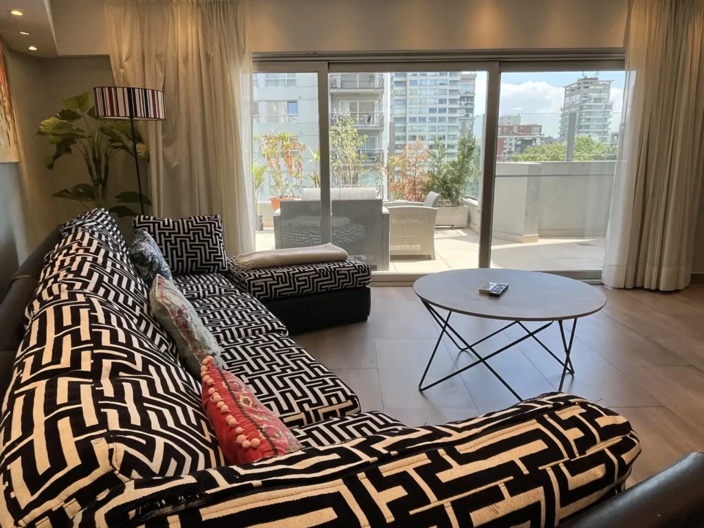 Patterned armchair by the window with terrace in the Shoshana Suite